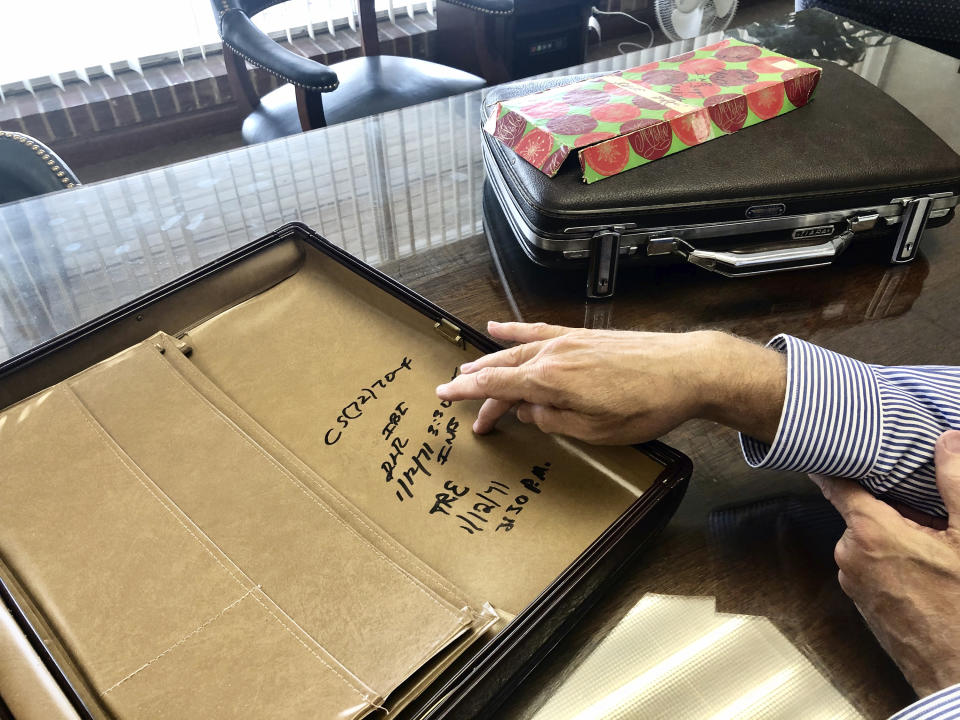 FILE - John Rendleman III, a Carbondale lawyer and Jackson County Board member, in this Oct. 8, 2020 photo, in Carbondale, Ill., points to markings made by officers of the Illinois Bureau of Investigation on Jan. 12, 1971, on an attache case that held some of the nearly $800,000 in cash found in a Springfield hotel suite belonging to then-Secretary of State Paul Powell. For more than half a century, a Powell-established $250,000 trust sustained his legacy, for better or worse. But the account that maintained his birthplace as a museum will soon run dry. (AP Photo/John O'Connor, File)