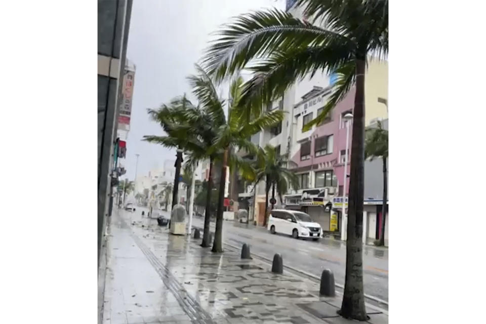 In this image made from video provided by EGL Tours, a car moves in the rain caused by Typhoon Khanun, in Naha, Okinawa, southern Japan, on Aug. 2, 2023. The typhoon that damaged homes and knocked out power on Okinawa and other southern Japanese islands this week was slowly moving west Thursday but is forecast to make a U-turn and dump even more rain on the archipelago.(EGL Tours via AP)