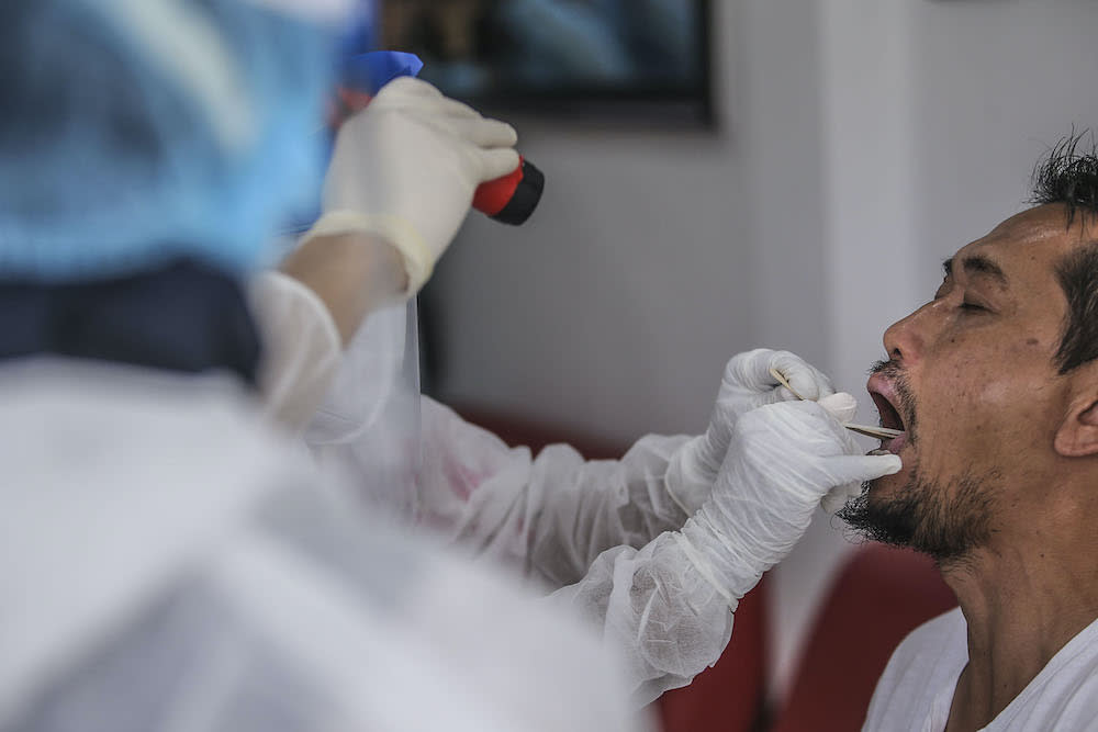 File photo of healthcare workers carry out Covid-19 screening for those with a recent travel history to Sabah at Selcare Clinic in Shah Alam October 4, 2020. — Picture by Hari Anggara