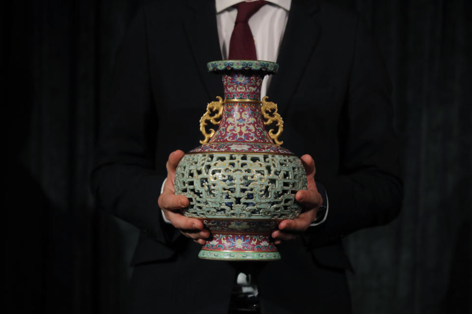 Un empleado de Sotheby's presenta el jarrón de porcelana china yangcai que se subastó por 9 millones de dólares. (AP Photo / Kin Cheung)