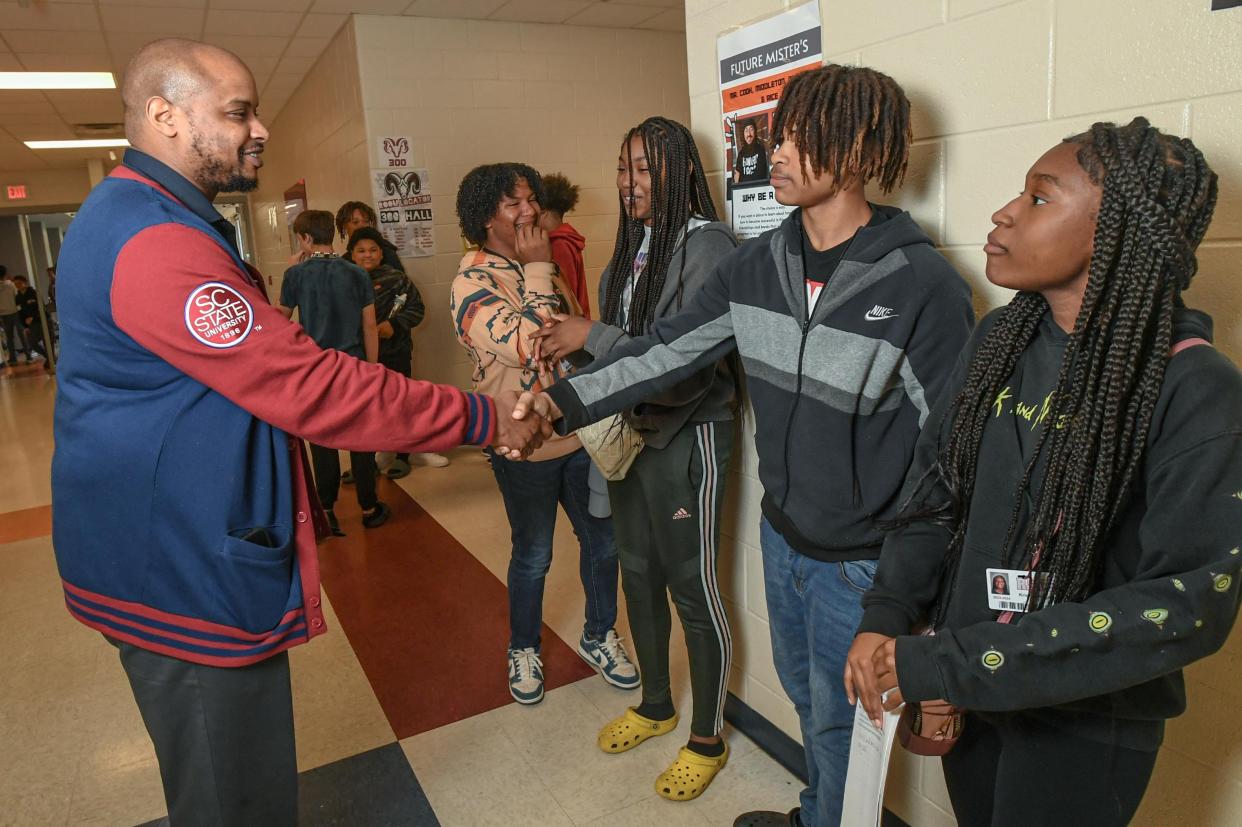 Principal Brian Williams shakes hands with Jeremih Hawkins, near Kristyn Rogers, right, Jayla Jones, left, and Braden Alexander, far left, in the hallway during lunch hour at Robert Anderson Middle School in Anderson, S.C. Wednesday, April 24, 2024.