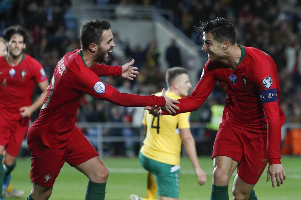 Portugal's Cristiano Ronaldo, right, celebrates with teammate Bernardo Silva after scoring their side's sixth goal during the Euro 2020 group B qualifying soccer match between Portugal and Lithuania at the Algarve stadium outside Faro, Portugal, Thursday, Nov. 14, 2019. (AP Photo/Armando Franca)