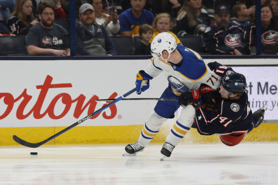 Columbus Blue Jackets' Hunter McKown, right, hooks Buffalo Sabres' Victor Olofsson during the first period of an NHL hockey game Friday, April 14, 2023, in Columbus, Ohio. McKown was penalized on the play. (AP Photo/Jay LaPrete)