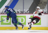 Vancouver Canucks' Jayce Hawryluk, left, sends Ottawa Senators' Artem Zub, of Russia, flying after a collision during the second period of an NHL hockey game in Vancouver, British Columbia, Thursday, April 22, 2021. (Darryl Dyck/The Canadian Press via AP)