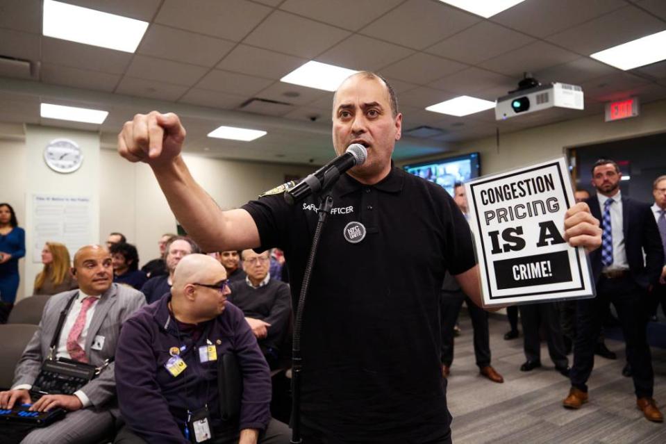 A member of the community argues against congestion pricing while holding a sign. James Keivom