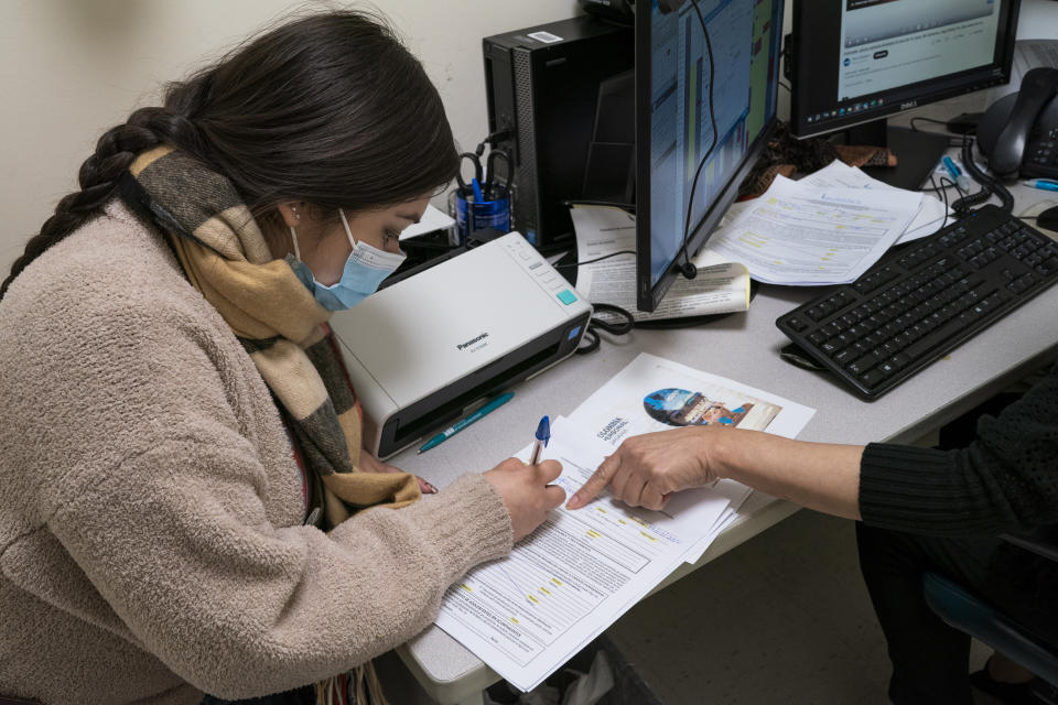 Luisa from Colombia fills out a form for medical treatment at the Plaza Del Sol Family Health Center in the Queens borough in New York, Thursday, Jan. 11, 2024. (AP Photo/Eduardo Munoz Alvarez)