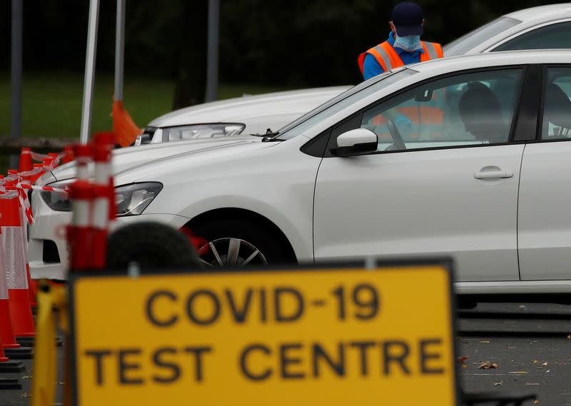 An NHS test and trace worker talks to a driver at a drive-through testing centre following the outbreak of the coronavirus disease (COVID-19) in Bolton, Britain
