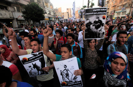 FILE PHOTO - Members of the April 6 movement and liberal activists shout slogans against a law restricting demonstrations as well as the crackdown on activists, in front of El-Thadiya presidential palace in Cairo April 26, 2014. The sign reads: "Down with the Egyptian judiciary." REUTERS/Amr Abdallah Dalsh/File Photo