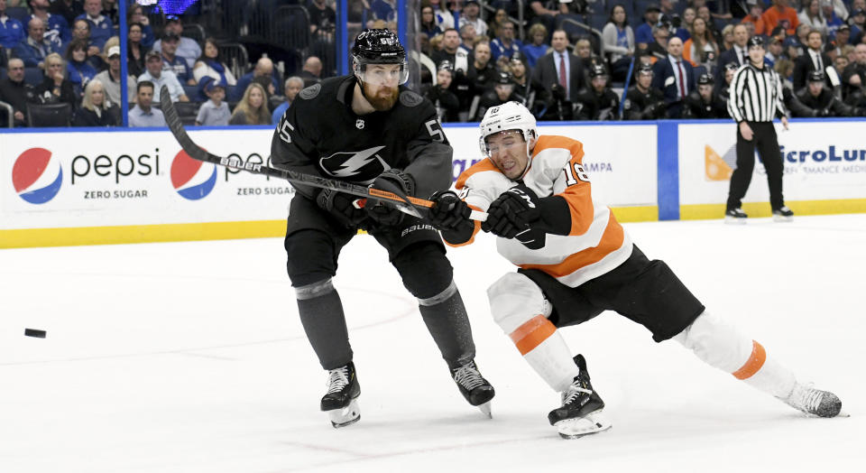 Tampa Bay Lightning defenseman Braydon Coburn (55) and Philadelphia Flyers center Tyler Pitlick (18) battle for the puck during the first period of an NHL hockey game Saturday, Feb. 15, 2020, in Tampa, Fla. (AP Photo/Jason Behnken)