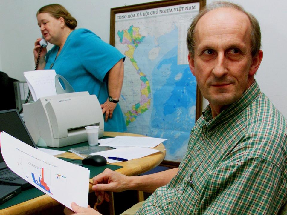 Karl Nicholson, a professor of infectious diseases, reviews SARS data collected from two hospitals in Hanoi, March 20, 2003.