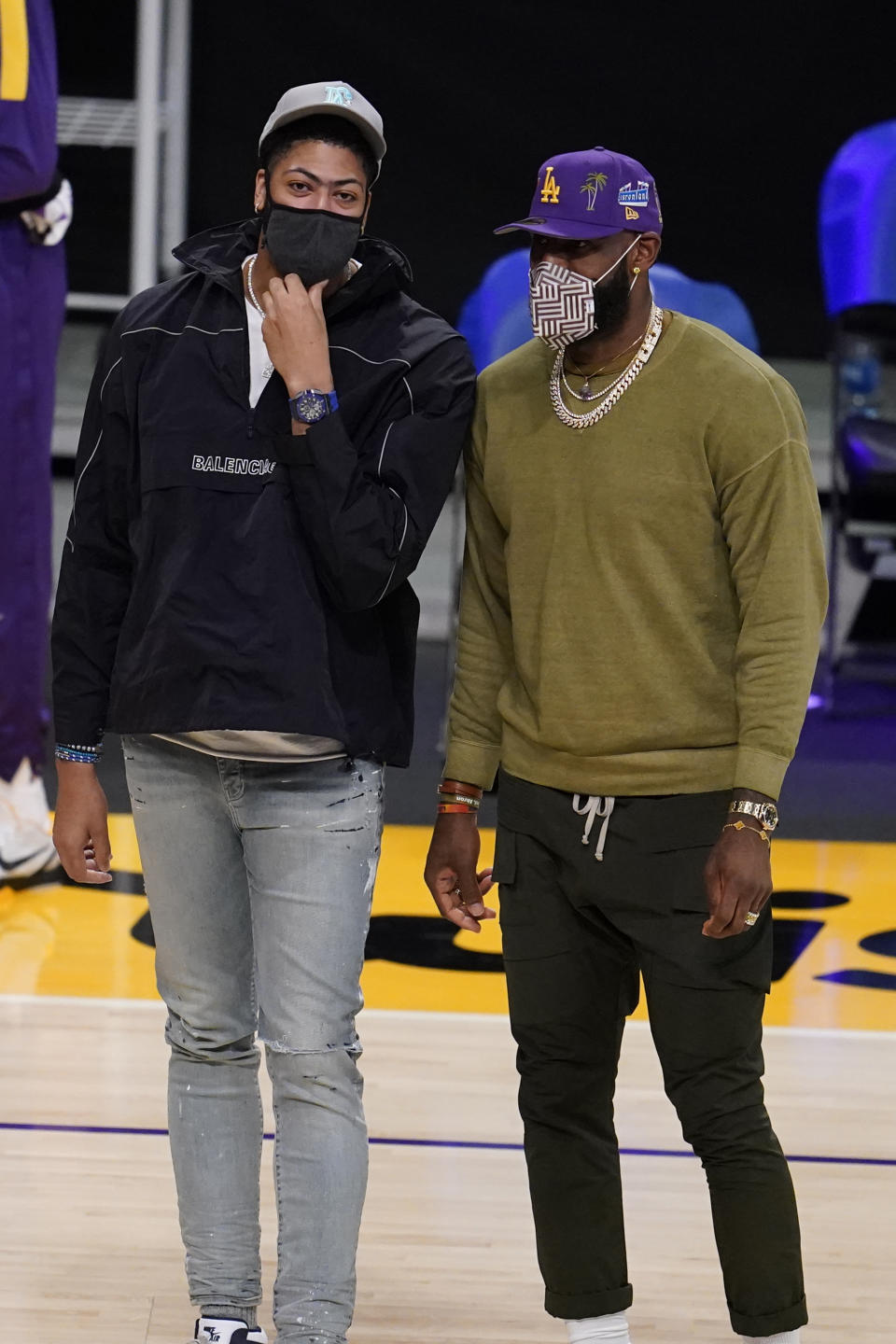 Los Angeles Lakers injured players Anthony Davis, left, and LeBron James talk on the court during a timeout during the first half of an NBA basketball game against the Utah Jazz Monday, April 19, 2021, in Los Angeles. (AP Photo/Marcio Jose Sanchez)