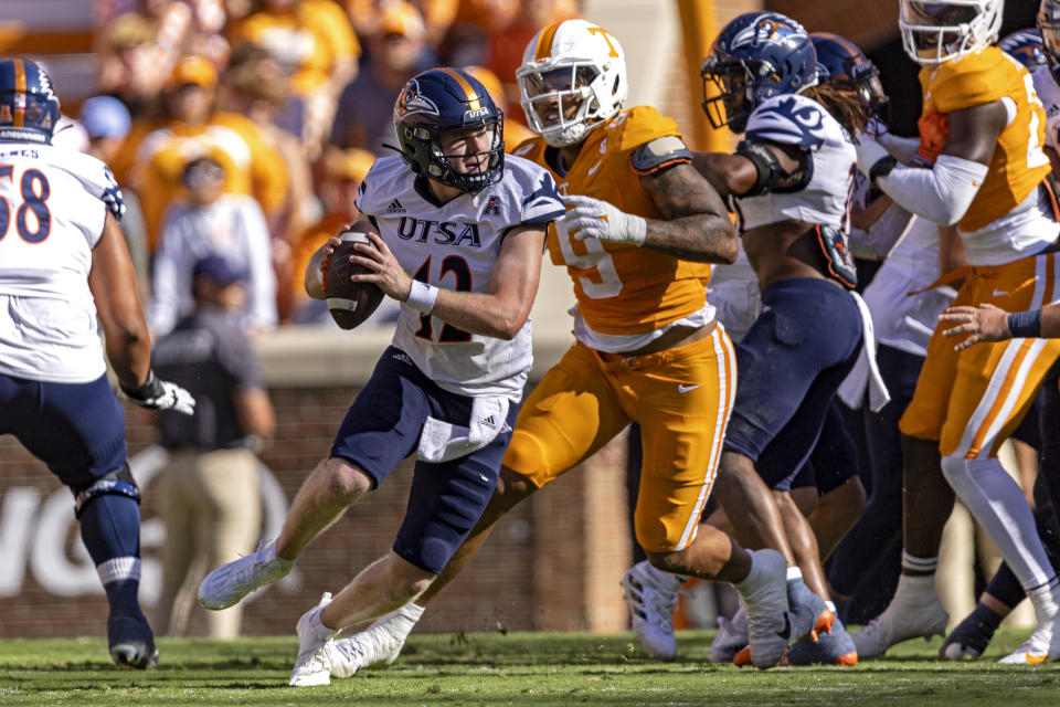 UTSA quarterback Eddie Lee Marburger (12) scrambles to avoid being tackled by Tennessee defensive lineman Tyler Baron (9) during the first half of an NCAA college football game Saturday, Sept. 23, 2023, in Knoxville, Tenn. (AP Photo/Wade Payne)