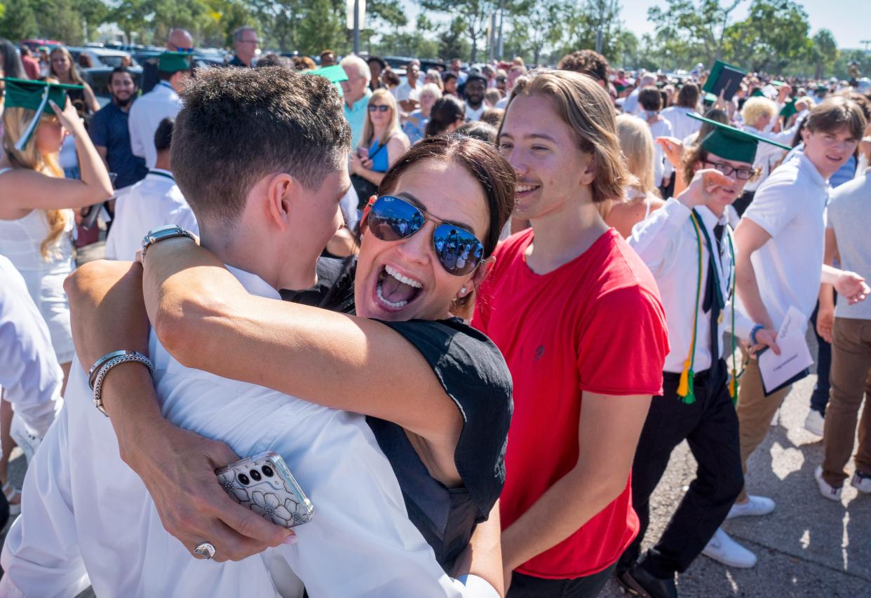 Vicki Revelle hugs her son Rylan Revelle after the Jupiter High School graduation at the South Florida Fairgrounds on May 18, 2023.