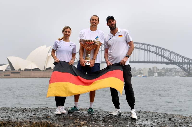 (L-R) United Cup 2024 winner's Angelique Kerber, Alexander Zverev, and Team Germany Captain Torben Beltz pose for pictures with the trophy at Mrs Macquaries Chair in Sydney. Team Germany won the second edition of the 2024 United Cup last night after defeating Team Poland 2-1 at Ken Rosewall Arena in Sydney. Bianca De Marchi/AAP/dpa