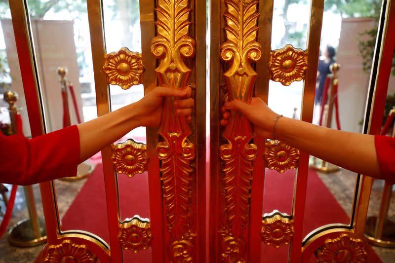 FILE PHOTO: Staff members open the doors of the newly inaugurated Dolce Hanoi Golden Lake luxury hotel, which features gold-plated exteriors and interiors, after the government eased a nationwide lockdown following the global outbreak of the coronavirus di