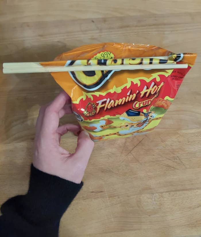 chopsticks keeping a Cheetos bag closed