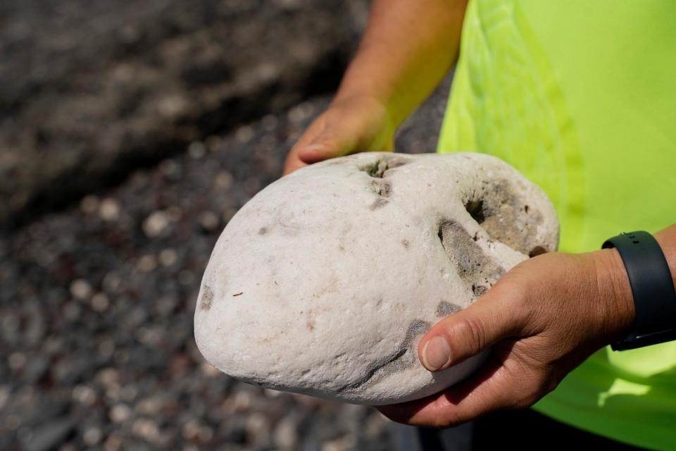 PHOTO: Ekolu Lindsey, a Lahaina community advocate who has long worked to restore coral reefs, fisheries and traditions in his hometown, picks up a pohaku puna coral reef at Olowalu Landing, Feb. 23, 2024, in Lahaina, Hawaii. (Mengshin Lin/AP)