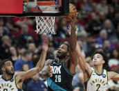 Portland Trail Blazers forward Justise Winslow, center, shoots between Indiana Pacers guards Trevelin Queen, left, and Andrew Nembhard during the second half of an NBA basketball game in Portland, Ore., Sunday, Dec. 4, 2022. (AP Photo/Craig Mitchelldyer)