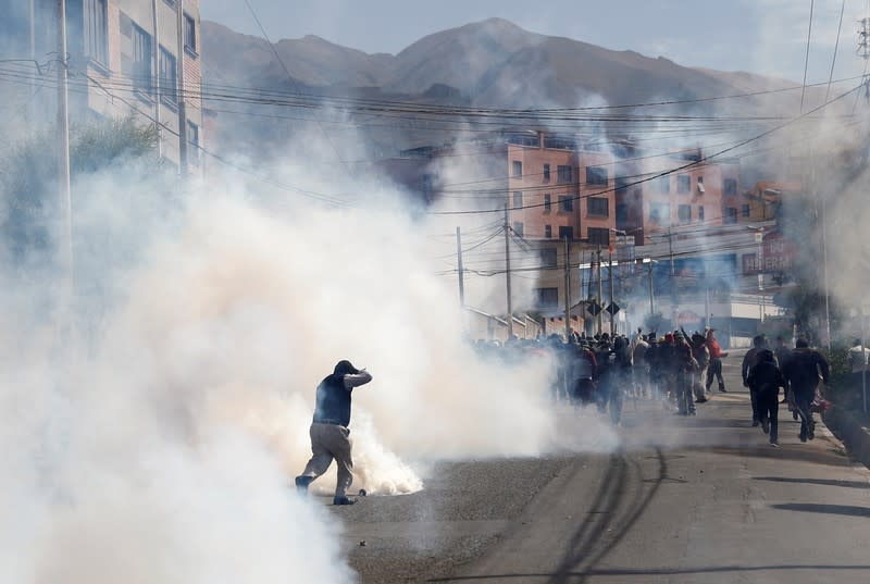 Supporters of Bolivia's President Evo Morales run away from tear gas during a protest in La Paz