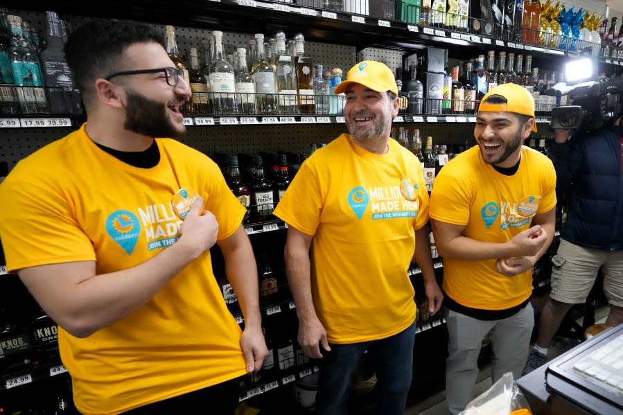 O coproprietário da loja Nidal Khalil, no centro, sorri com seu filho Jonathan Khalil, à esquerda, e seu sobrinho Chris Khalil, à direita, após usar camisetas na loja Midway Market & Liquor, quinta-feira, 12 de outubro de 2023, em Frazier Park, Califórnia, onde foi realizada a venda. Bilhete de loteria vencedor da Powerball.  Um jogador da Califórnia ganhou o jackpot de US$ 1,765 bilhão na noite de quarta-feira, encerrando um longo período sem vencedor do jackpot.  (AP Photo/Márcio José Sanchez)