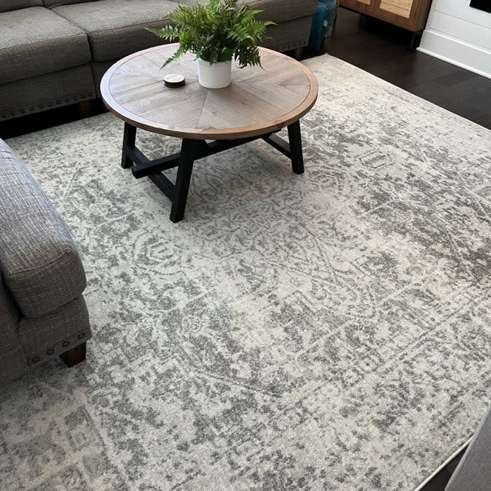 Reviewer's photo of grey rug with a table and couch.