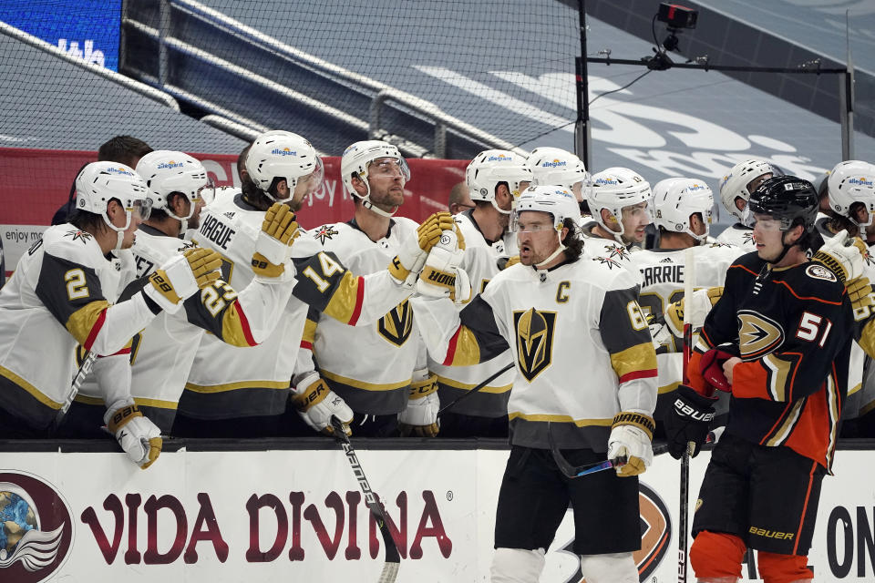 Vegas Golden Knights right wing Mark Stone, center right, high-fives teammates on the bench after scoring during the second period of an NHL hockey game against the Anaheim Ducks, Sunday, April 18, 2021, in Anaheim, Calif. (AP Photo/Marcio Jose Sanchez)