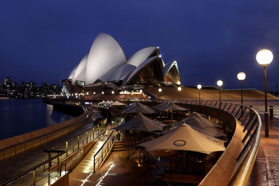 Closed bars and restaurants along the Sydney Opera House forecourt at Circular Quay during a lockdown imposed due to the coronavirus, at night in Sydney.