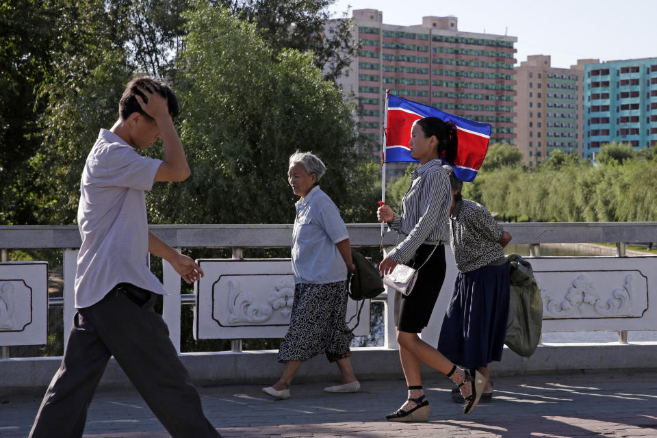 A woman carries a North Korean flag on the streets of Pyongyang, North Korea, Friday, Sept. 7, 2018. North Korea will be staging a major military parade, huge rallies and reviving its iconic mass games on Sunday to mark its 70th anniversary as a nation. (AP Photo/Kin Cheung)