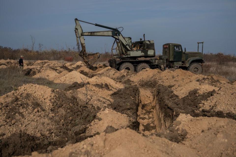 An engineer operates a military excavator to dig a trench system on Nov. 2, 2022, near Bashtanka, Mykolaiv Oblast. (Carl Court/Getty Images)