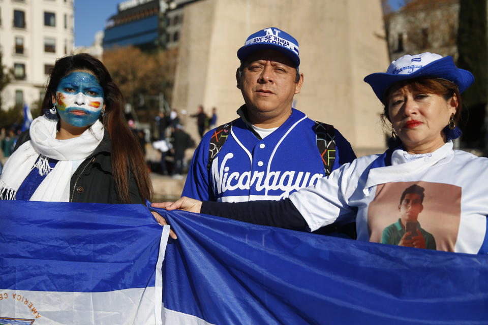 FILE - In this Jan. 12, 2019 file photo, Roberto Davila, center, father of Kevin Roberto, a 23-year-old veterinary student killed during a protest in Nicaragua, and two relatives attend a protest against the Nicaraguan government in Madrid, Spain. The nationwide protests began April 18, initially drawing mostly senior citizens who were the most directly impacted by the announced social security cuts. When the elderly protesters were met with violence from pro-government Sandinista Youth thugs, students turned out in large numbers to defend them. (AP Photo/Andrea Comas, File)