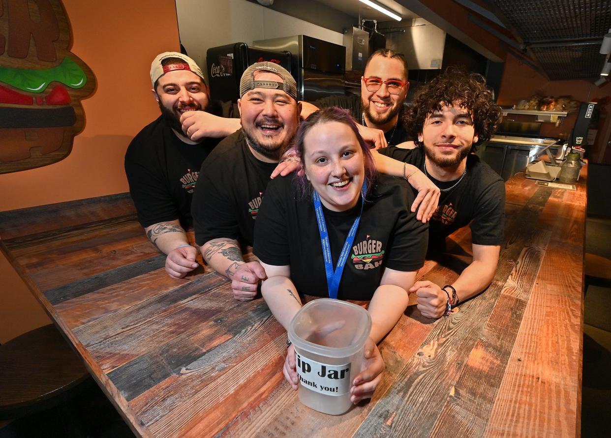 Burger Bah employee Samantha Arglin, center, with her co-workers, from left, Mateo Furtado-Valle, Drew Day, Khris Perez and Jonathan Bowman. Arglin lost her home recently in a three-decker fire and her coworkers are donating their tips to help her.