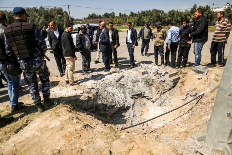 Hamas security force members inspect the crater left by a bomb that targeted the convoy of Palestinian prime minister Rami Hamdallah on a rare visit to the Gaza Strip on March 13, 2018