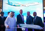 Etihad COO Mohammad Al-Bulooki, Etihad CEO Tony Douglas, Boeing Commercial Airplanes president, CEO Stanley A. Deal and Boeing Global Services President and CEO Ted Colbert pose for a photo in front of a Boeing 787 Dreamliner model at Dubai Air show, Dubai