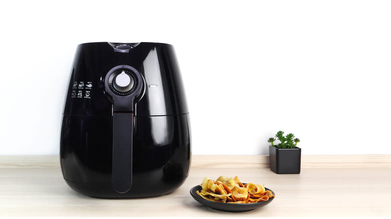 Air fryer and plate of chips.