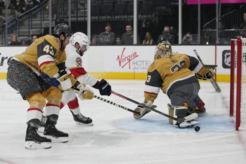 Florida Panthers defenseman Aaron Ekblad (5) attempts a shot on Vegas Golden Knights goaltender Adin Hill (33) during the first period of an NHL hockey game Thursday, Jan. 12, 2023, in Las Vegas. (AP Photo/John Locher)