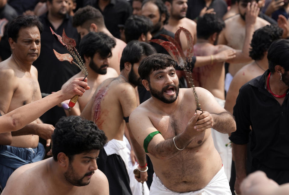 Shiite Muslims flagellate themselves with knifes on chains during a procession to mark Ashoura, in Islamabad, Pakistan, Friday, July 28, 2023. Ashoura is the Shiite Muslim commemoration marking the death of Hussein, the grandson of the Prophet Muhammad, at the Battle of Karbala in present-day Iraq in the 7th century. (AP Photo/Rahmat Gul)