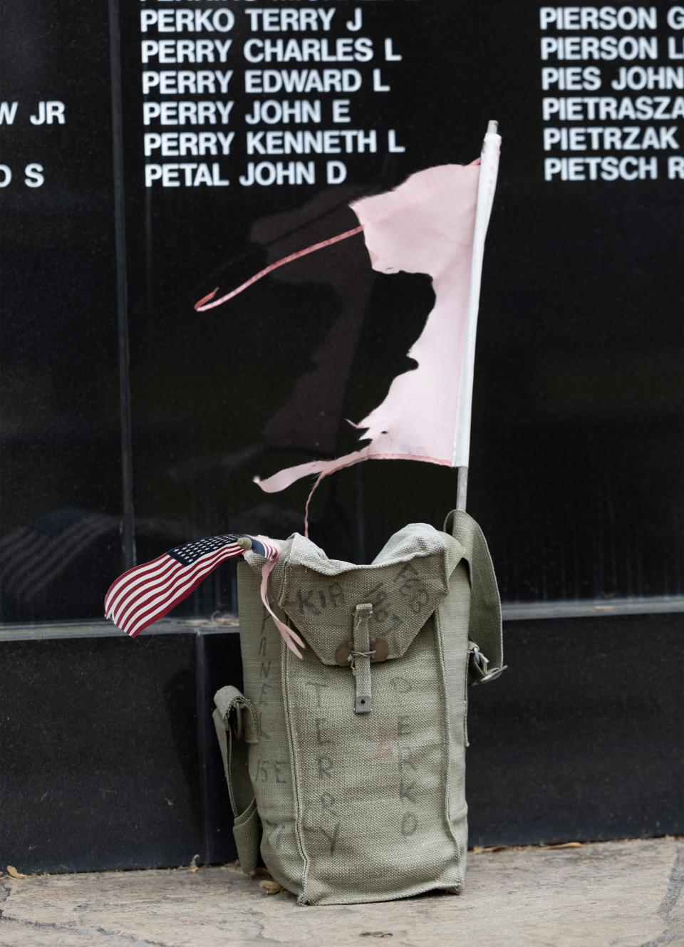 A utility bag sits under the name of veteran Terry Perko, one of the 3,095 Ohioans who gave their lives in service to the nation during the Vietnam War. The names are engraved on a wall at the Ohio Veterans' Memorial Park in Clinton.