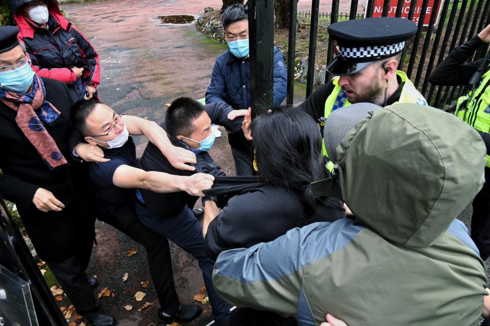 In this Handout provided by Matthew Leung, Hong Kong protester Bob Chan scuffles with people who are trying to drag him into the Chinese consulate in Manchester, England, Sunday Oct. 16, 2022. Bob Chan said he and others were holding a peaceful antigovernment protest outside the consulate on Sunday when masked men came out, tore down the protesters’ banners and dragged him inside the buildings gates. (Matthew Leung/The Chaser News via AP)