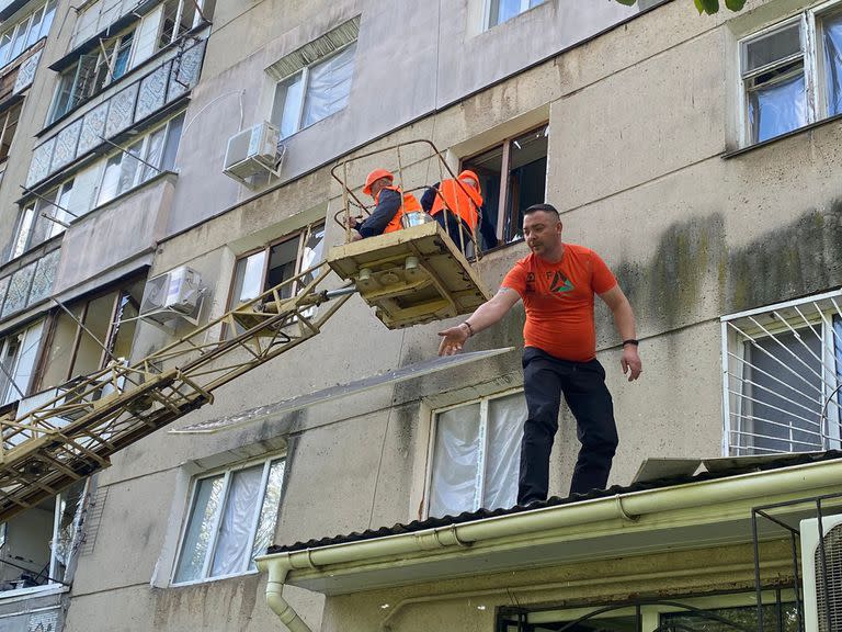 Obreros de la municipalidad Odessa reparando departamentos y sacando escombros