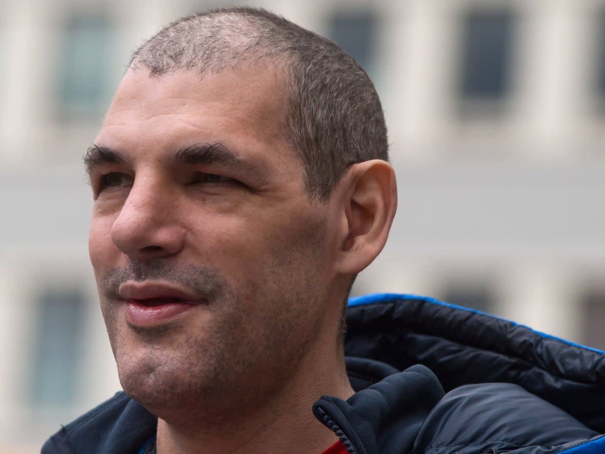 Former Vancouver Canucks' enforcer Gino Odjick pauses to look at the hundreds of fans that gathered to support him outside Vancouver General Hospital on June 29, 2014.  (Darryl Dyck/The Canadian Press - image credit)