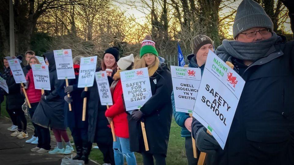 Teachers on a picket line holding signs about school safety in January