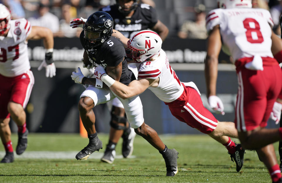 Colorado wide receiver Jimmy Horn Jr., left, is pulled down after a short gain by Nebraska defensive back Isaac Gifford in the first half of an NCAA college football game Saturday, Sept. 9, 2023, in Boulder, Colo. (AP Photo/David Zalubowski)