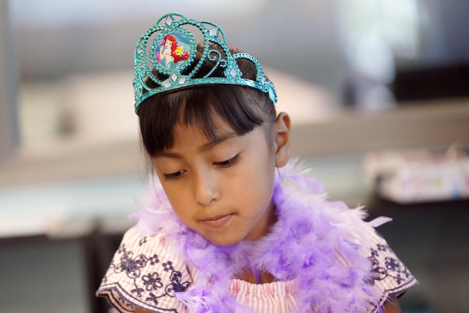 Nuria Castaneda wears a toy crown while playing a game of Jenga with a mentor at a Friends of the Children office Wednesday, Aug. 24, 2022, in Lancaster, Calif. Billionaire philanthropist MacKenzie Scott donated $44 million to the Oregon-based mentoring organization, Friends of the Children, which supports children at risk of entering the welfare system by pairing them with a longtime mentor. (AP Photo/Marcio Jose Sanchez)