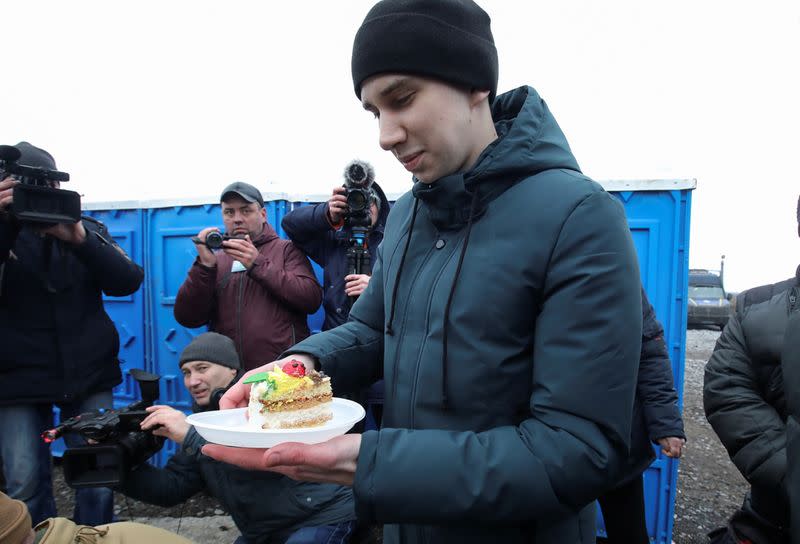 A Ukrainian citizen receives a slice of cake during a welcoming ceremony following prisoner of war exchange in Donetsk region