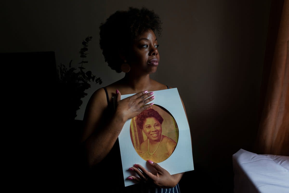 Nicole Sharpe holds a photograph of her mother, Heather Hurley, who was killed by her father when Sharpe was a teenager (Reuters)