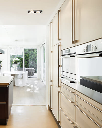 Simple, unfussy square-edged lines and flat-fronted doors and drawers are the hallmarks of this contemporary kitchen. A combo of laminate solids and patterns will help provide the cafe character. As for the woodgrain, mix it up: glossy and a horizontal run on the island can switch to matt and vertical for the shelving.