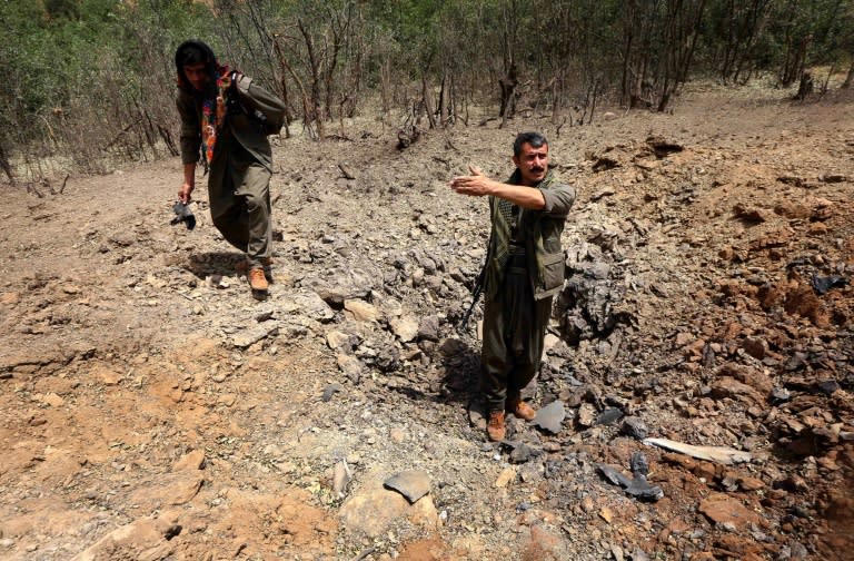 Members of the Kurdistan Workers' Party (PKK) inspect a crater reportedly caused by a Turkish air strike on July 29, 2015 in the Qandil mountain, the PKK headquarters in northern Iraq