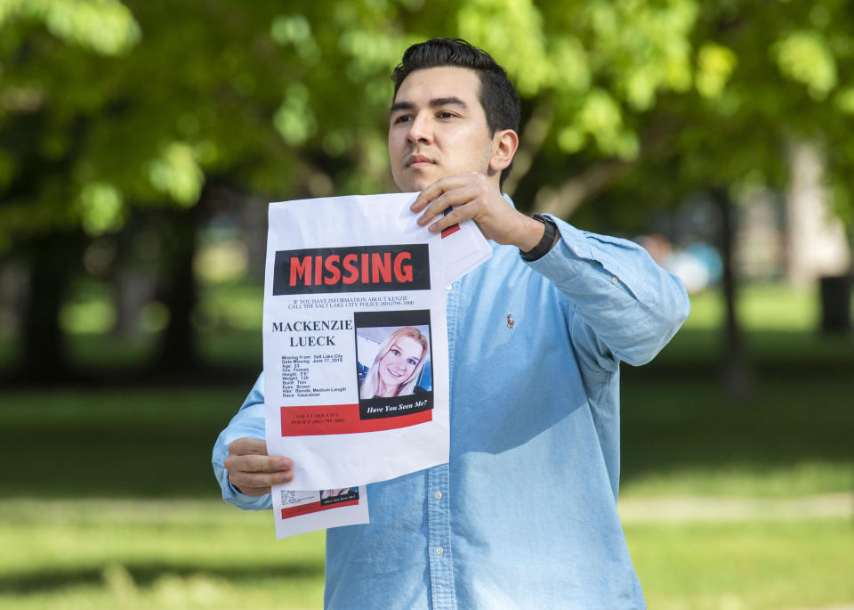 In this Saturday, June 22, 2019 photo, Nate Crispo holds a holds a sign with Mackenzie Lueck's photo in Liberty Park in Salt Lake City. Police and friends are investigating the disappearance of the 23-year-old University of Utah student, whose last communication with her family said she arrived at Salt Lake City International Airport on Monday, June 17. (Rick Egan/The Salt Lake Tribune via AP)