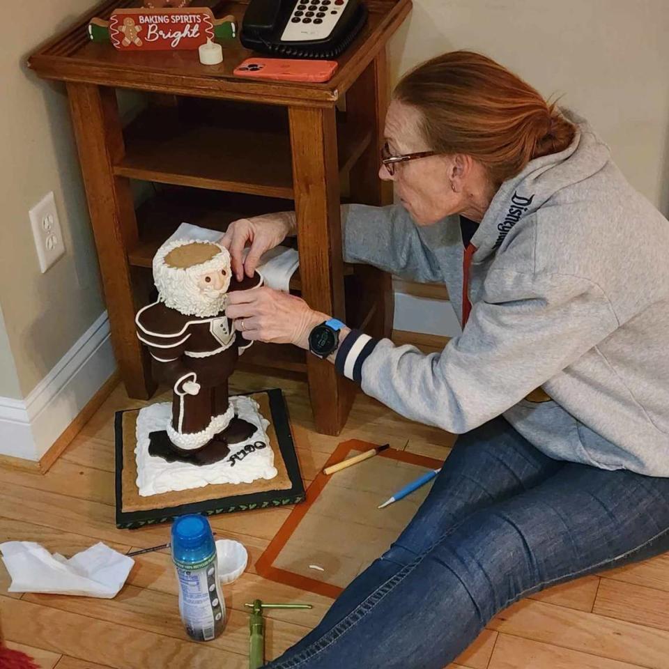 Juli Bisenius fixes Harold the Nutcracker, who broke at the ankles and face-planted on the counter the day before the National Gingerbread House Competition at Omni Grove Park in Asheville.