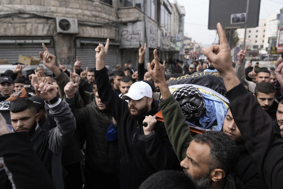 Gunmen carry the bodies of Said Jaradat, left, and Yasser Hanoun, both draped in the flag of the Islamic Jihad militant group, on Friday, Feb. 23, 2024. The pair were killed in an Israeli drone strike on a car in the West Bank Jenin refugee camp a day earlier. The Israeli military alleged that Hanoun was previously involved in several shooting attacks targeting Israeli settlements and army posts. (AP Photo/Majdi Mohammed)